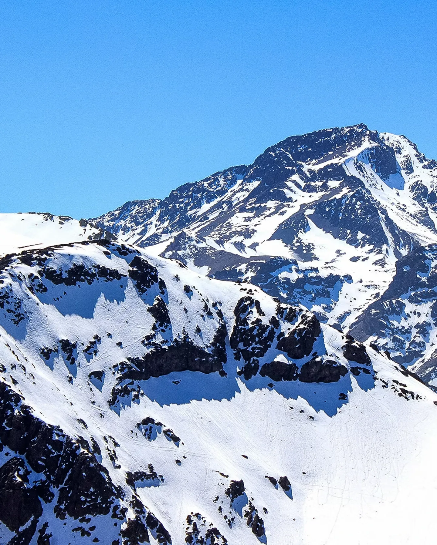 Snow-capped mountain peaks under a clear blue sky